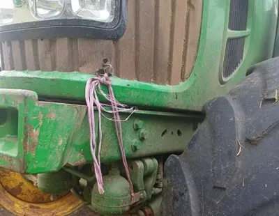 Purple Impax agricultural Twine holding together front of green tractor